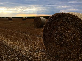 Hay bales on field against sky