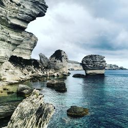 Rocks on sea shore against sky