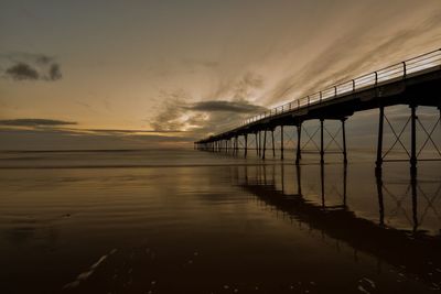 Surface level view of pier at sunset