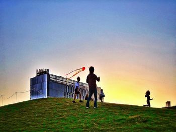 Silhouette people standing against clear sky