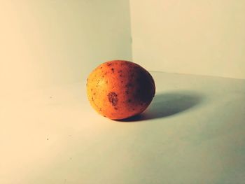 Close-up of apple on table against orange background