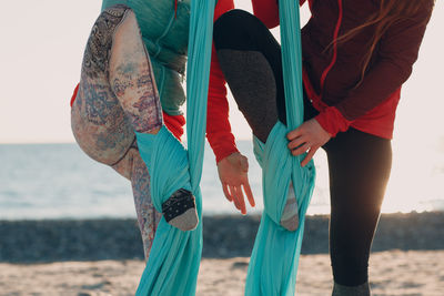 Low section of women dancing on beach