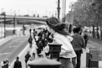 Rear view of woman walking on road in city