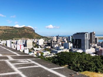 City street by buildings against blue sky