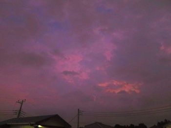 Low angle view of silhouette power lines against sky at sunset