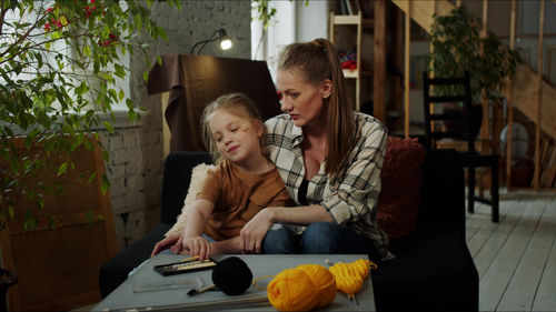 Mother teaching crocheting to daughter