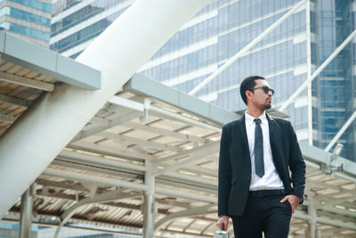 Full length of a young man standing at office building