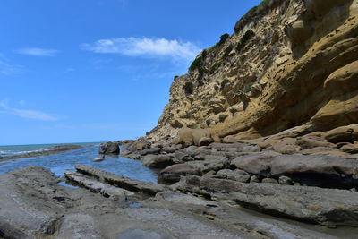 Scenic view of rocky beach against sky