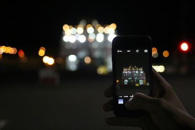 Cropped image of man photographing through smart phone