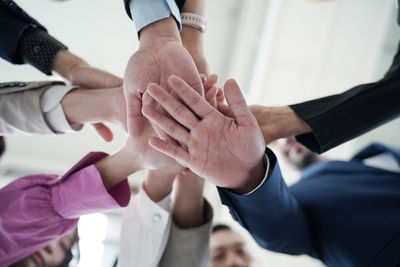 Midsection of business people stacking hands