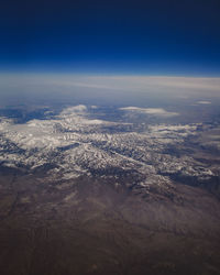 Aerial view of dramatic landscape against blue sky