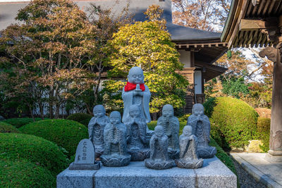 Statue against trees and building