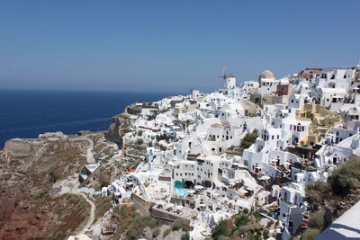 High angle view of townscape by sea against clear sky