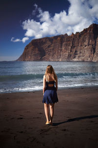 Full length of woman on beach against sky