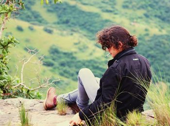 Side view of man sitting on land