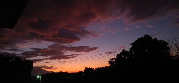 Low angle view of silhouette buildings against sky at sunset