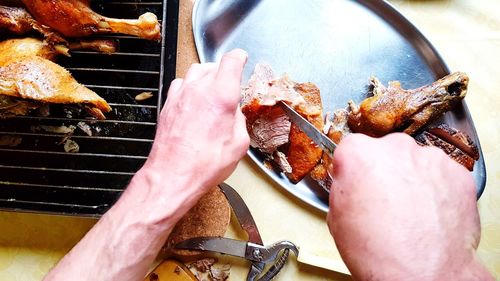 Midsection of man preparing food on barbecue grill