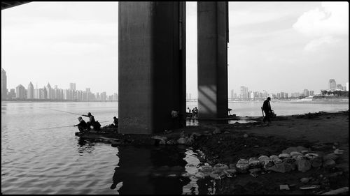 People in river with city in background