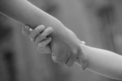 Cropped image of mother and daughter with holding hands