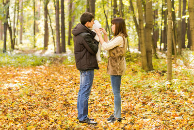 Young couple kissing in forest during autumn