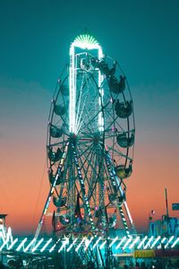 Low angle view of illuminated ferris wheel against sky at night