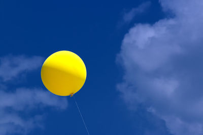 Low angle view of balloons against blue sky