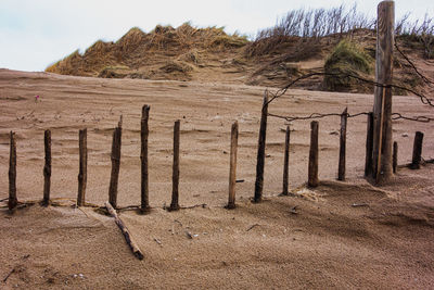 Wooden fence on field against sky