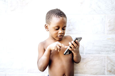 Nice african boy has fun using a mobile phone.