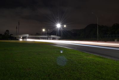 Light trails on street against sky at night