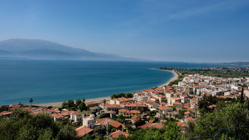 High angle view of townscape by sea against sky