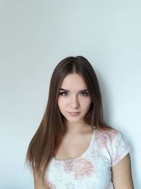 Portrait of beautiful young woman against wall