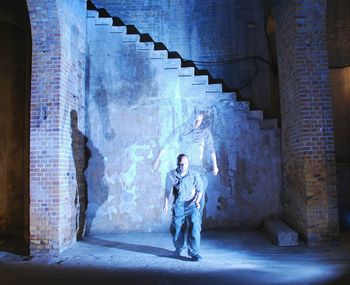 Multiple image of man standing in abandoned building