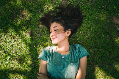 Portrait of young woman sitting on grassy field