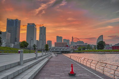 View of buildings at waterfront against cloudy sky