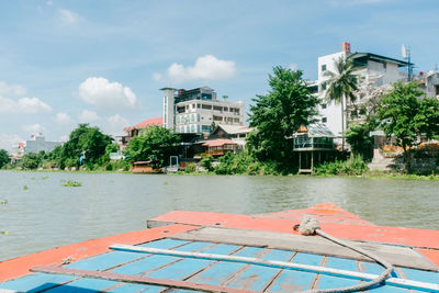 Scenic view of river by buildings against sky