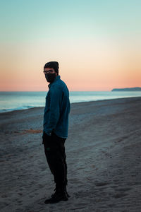 Full length of man standing on beach during sunset