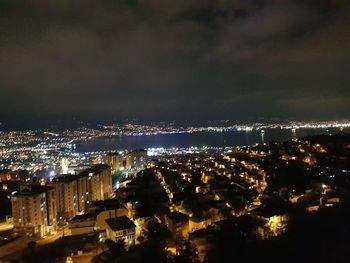 Illuminated cityscape against sky at night