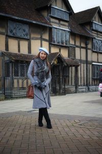 Portrait of woman standing against built structure