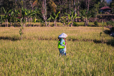 Rear view of man walking on field