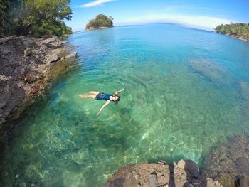 Fish-eye view of woman swimming in sea