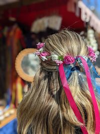 Preparing for a festival. rear view of blond woman with mirror standing against blurred background