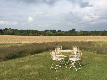 View of empty chairs on field against sky