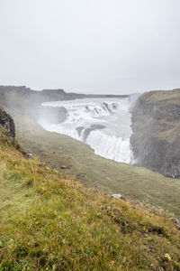 Scenic view of waterfall against clear sky