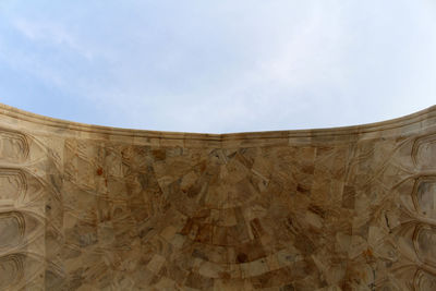 Low angle view of stone wall against sky