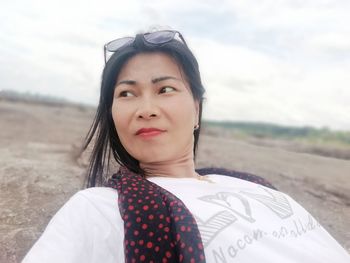 Portrait of woman standing on field against sky