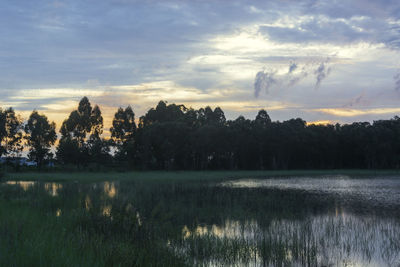 Scenic view of lake against sky at sunset