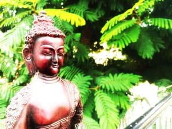 Close-up of buddha statue against trees