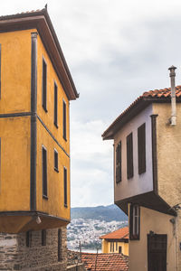 Buildings in town against cloudy sky