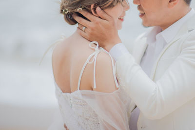 Midsection of romantic newlywed couple standing outdoors