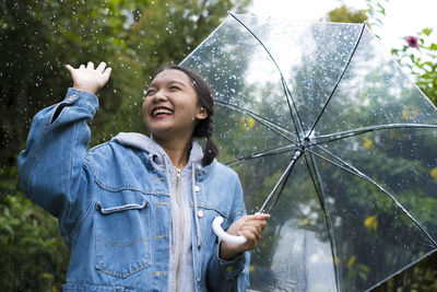 Happy woman standing on wet rainy day